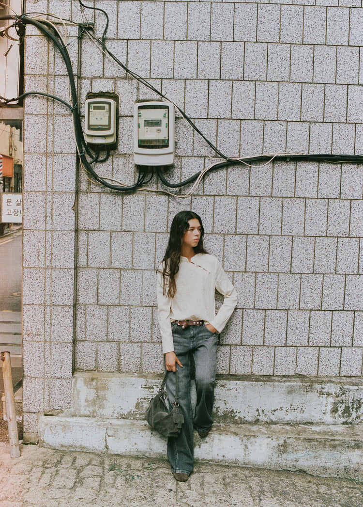 Jeans de tiro medio en gris oscuro sobre modelo con la mano en el bolsillo
