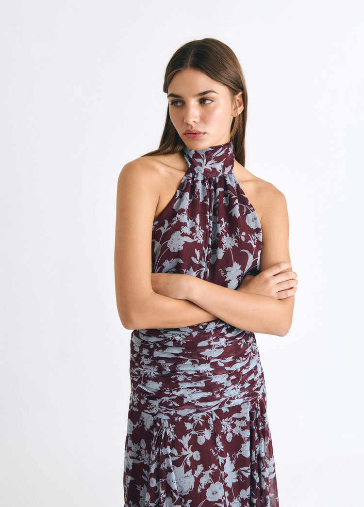 Vestido largo de cuello alto con estampado floral en tono granate sobre modelo