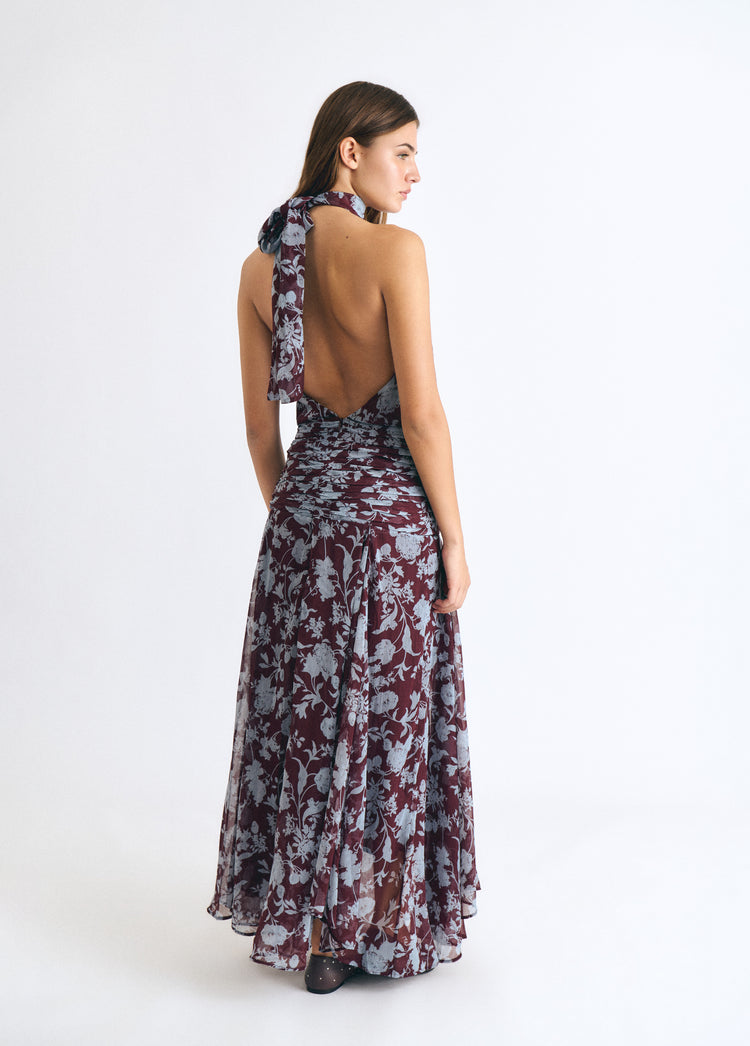 Vestido largo estampado en tono granate con espalda descubierta y tirante halter sobre modelo