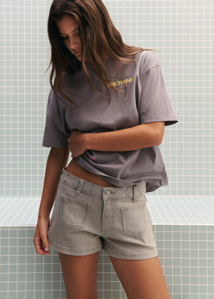 Camiseta gris con el estampado de texto en el pecho lucida sobre modelo