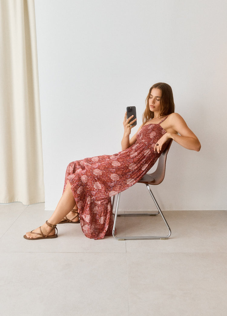 Vestido largo de tirantes finos en tono rosado con estampado floral, luciendo caída fluida y falda vaporosa