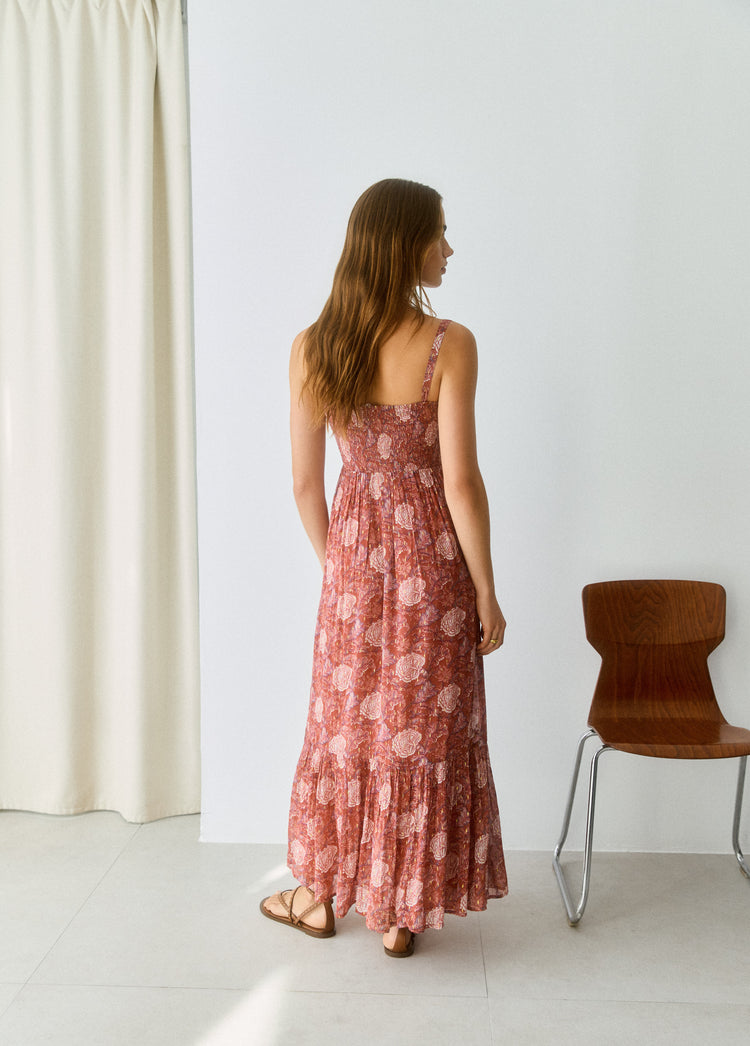 Vestido largo de tirantes en tono rosado con estampado floral visto desde la espalda