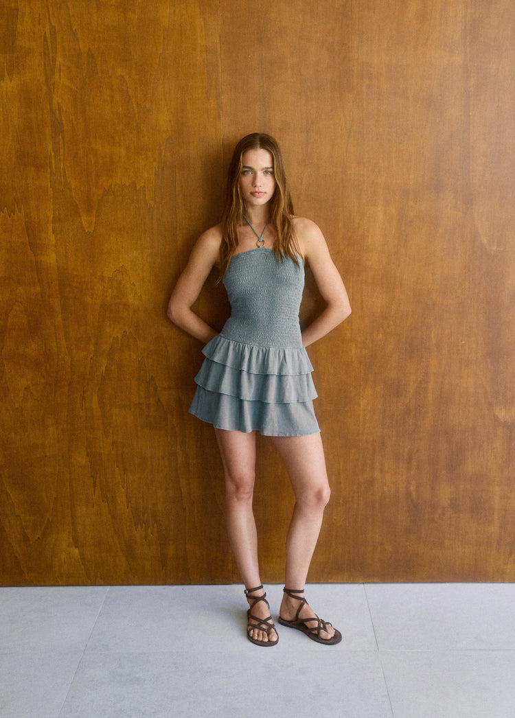 Vestido smock de tirantes y falda de volantes en tono verdoso visto de cuerpo entero