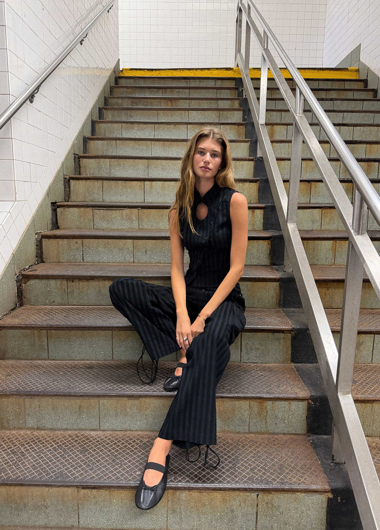 Pantalón cargo de pana con rayas en negro lucido sobre modelo mostrando su caída y los cordones en los bajos