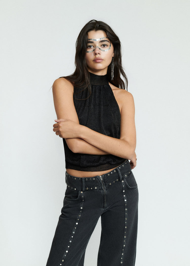 Tejano negro con tachas y cremallera frontal sobre modelo