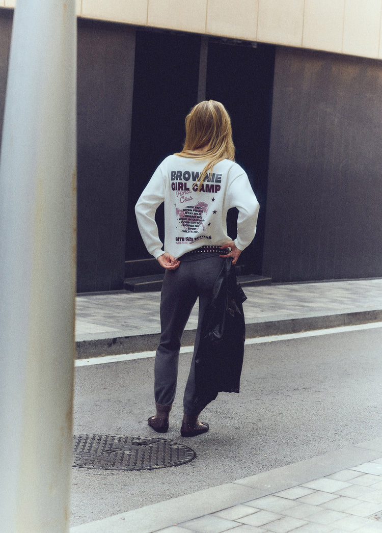 Sudadera blanca con estampado de texto y estrellas en la espalda sobre modelo