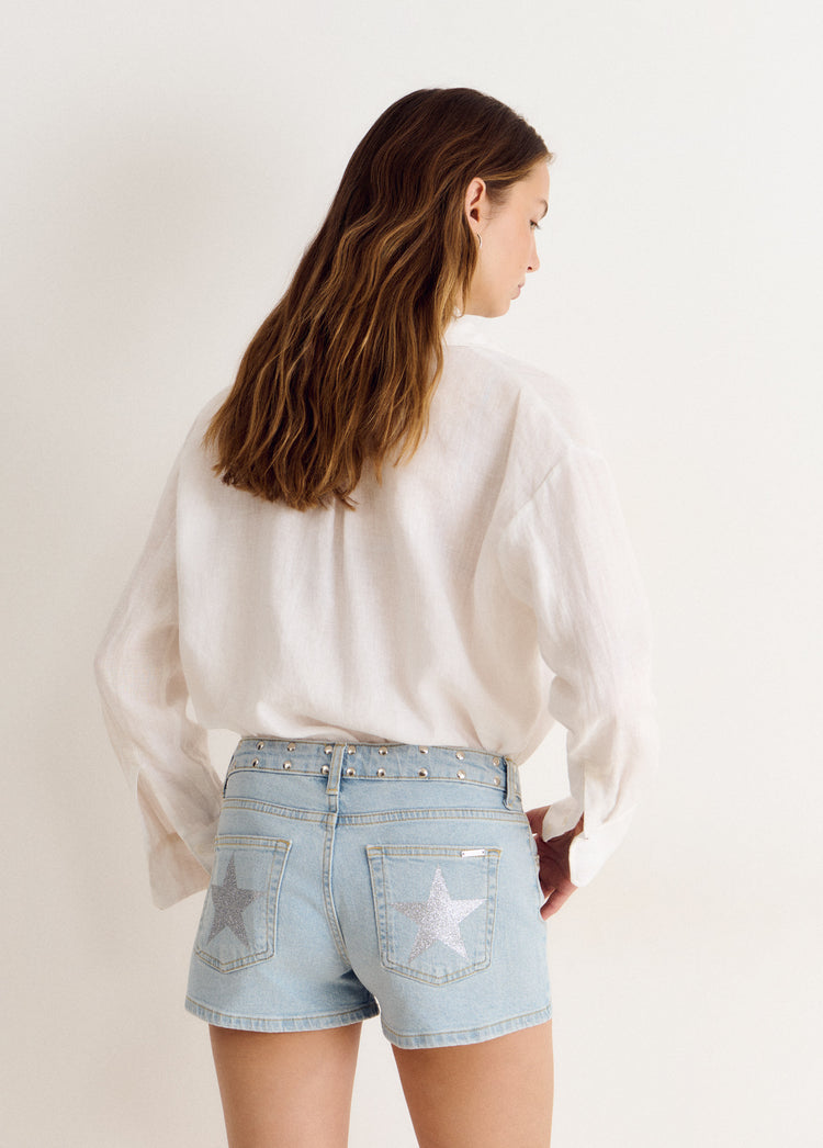 Short vaquero azul claro con tachas metálicas y estrellas glitter en los bolsillos traseros