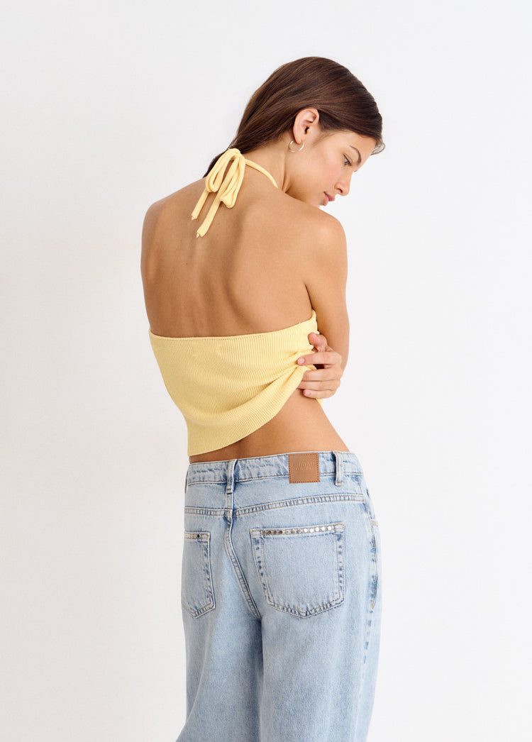 Top halter de punto amarillo visto de espaldas con lazo en el cuello