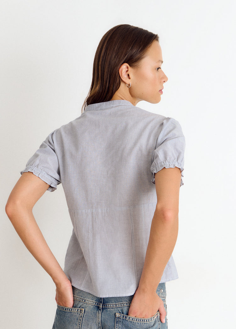 Blusa de manga corta con rayas en azul vista por la espalda sobre modelo
