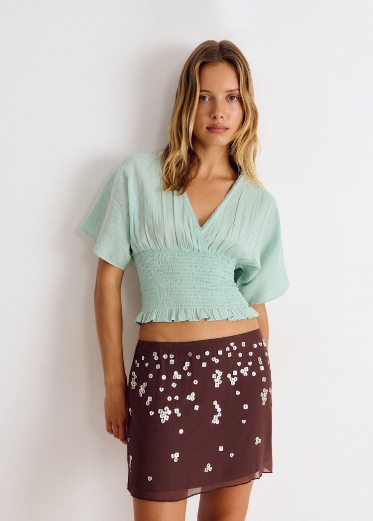 Falda midi de color chocolate con lentejuelas plateadas esparcidas por toda la superficie