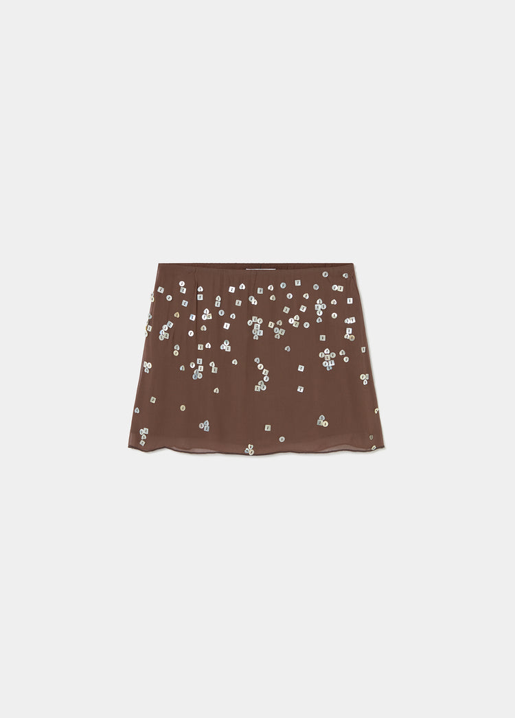 Falda corta de color chocolate con escarapelas de lentejuelas plateadas distribuidas por toda su superficie