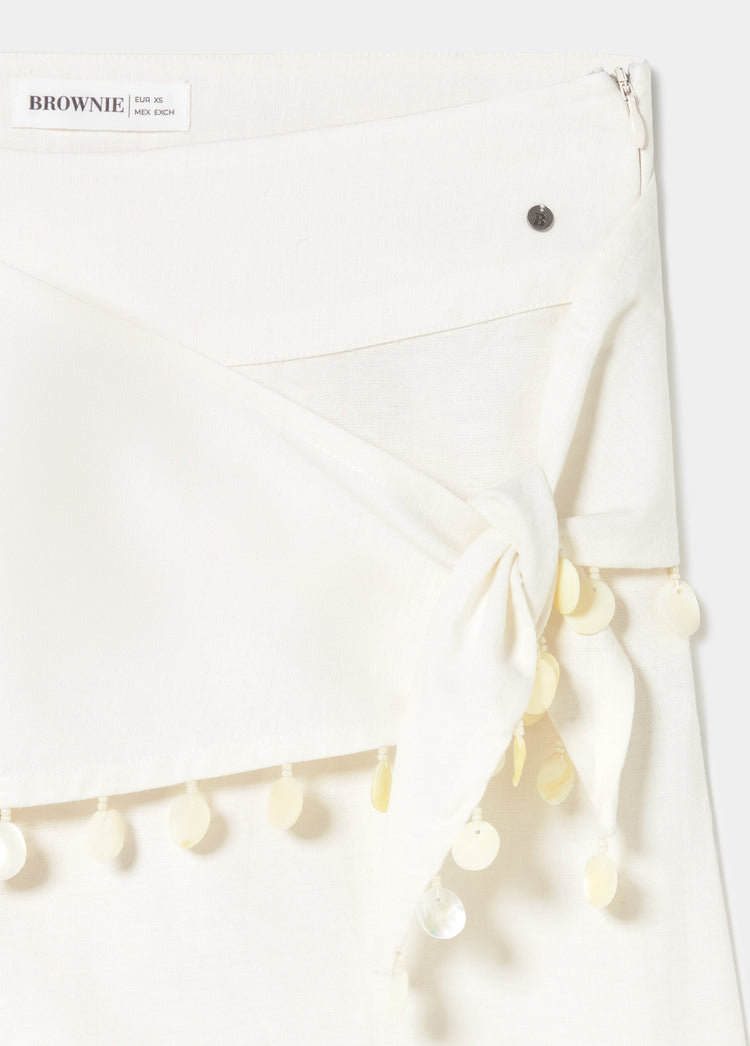 Pantalón pareo blanco con lazo y colgantes de conchas en la cintura