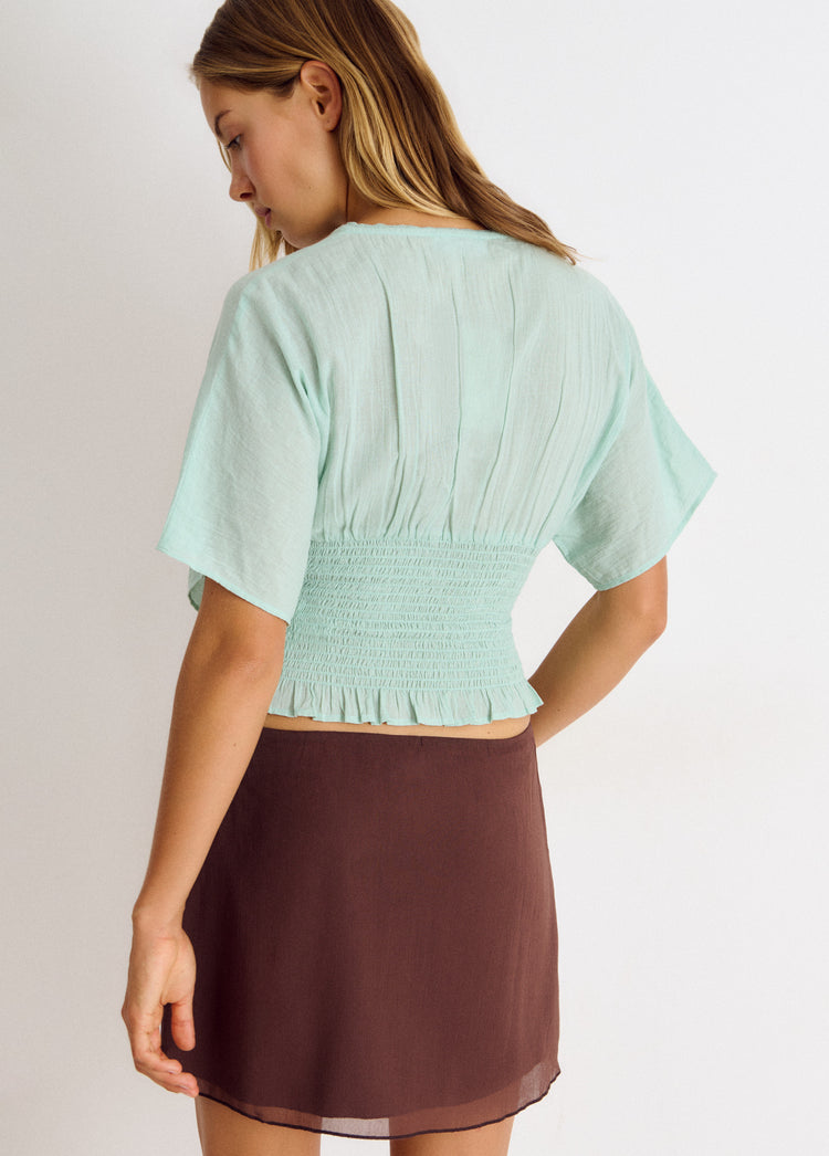 Blusa smock de manga corta en color turquesa vista por la espalda