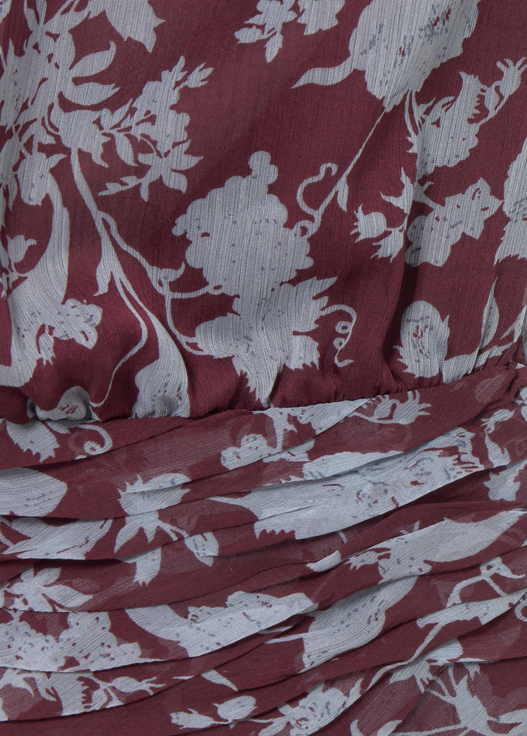 Detalle de la tela del vestido largo estampado en tono granate con pliegues y caída fluida