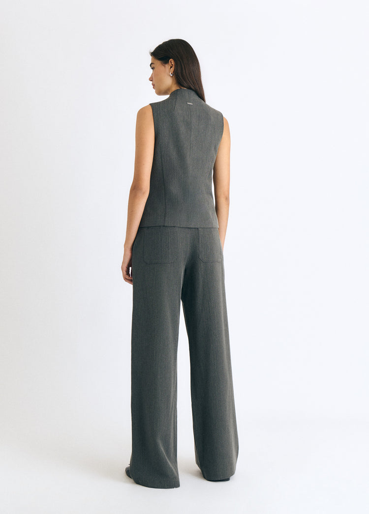 Pantalón gris de pierna ancha con cremallera visto por detrás sobre modelo
