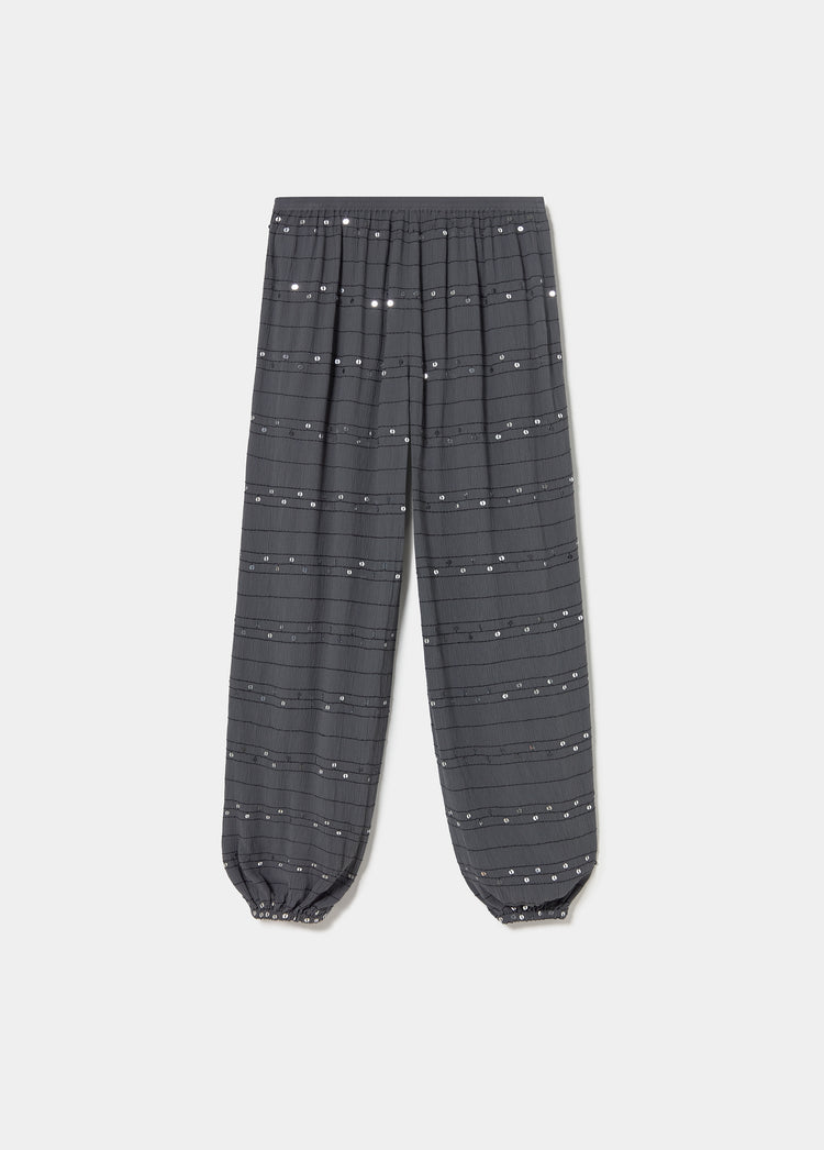 Pantalón bombacho antracita con lentejuelas plateadas distribuidas en líneas horizontales y puños elásticos