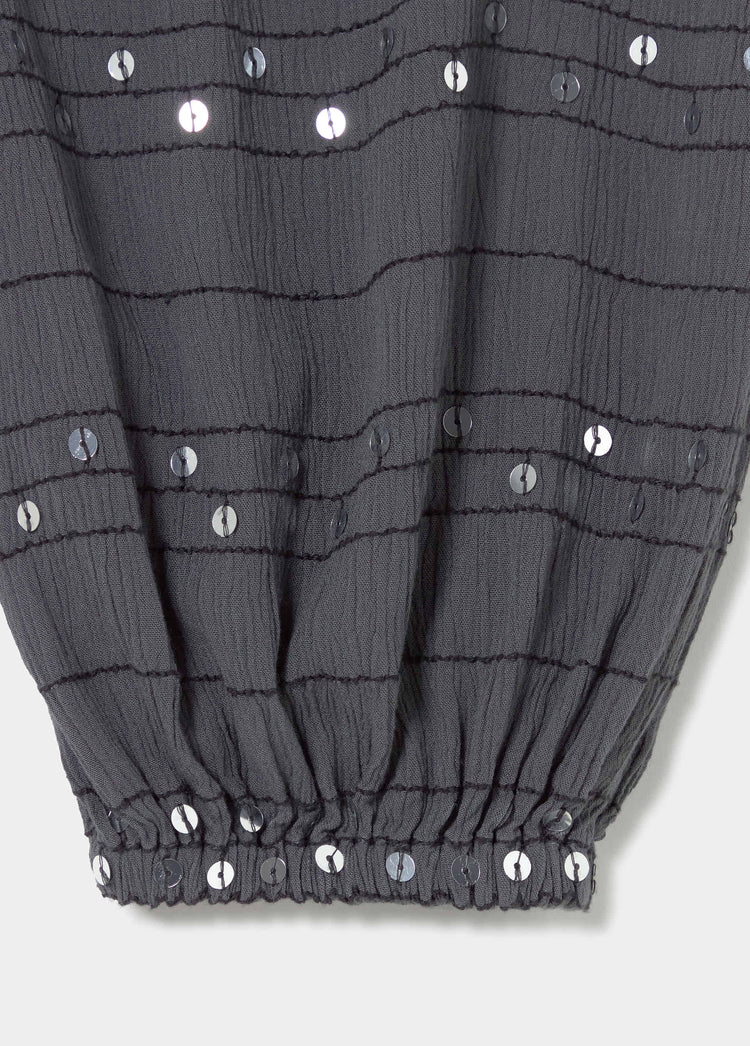 Detalle del bajo del pantalón bombacho antracita con lentejuelas plateadas y puño elástico