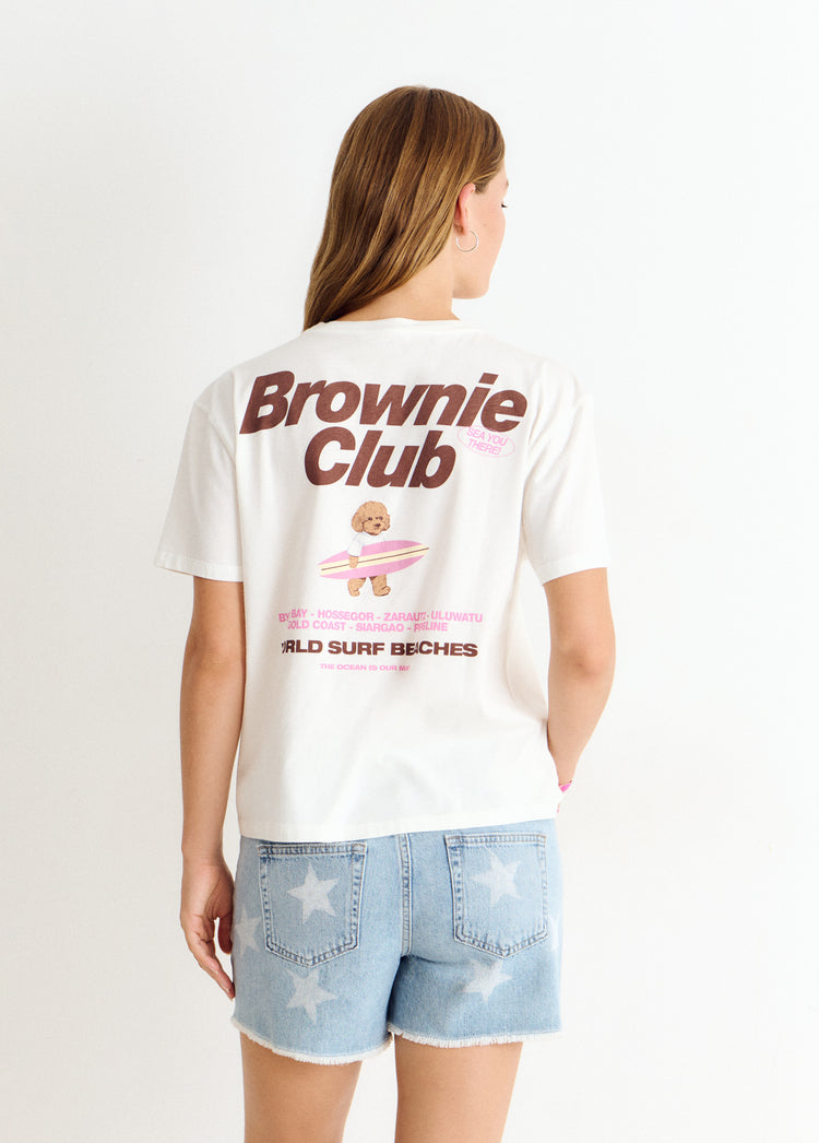 Camiseta de color blanco con estampa de perro surfero y logotipo en la espalda