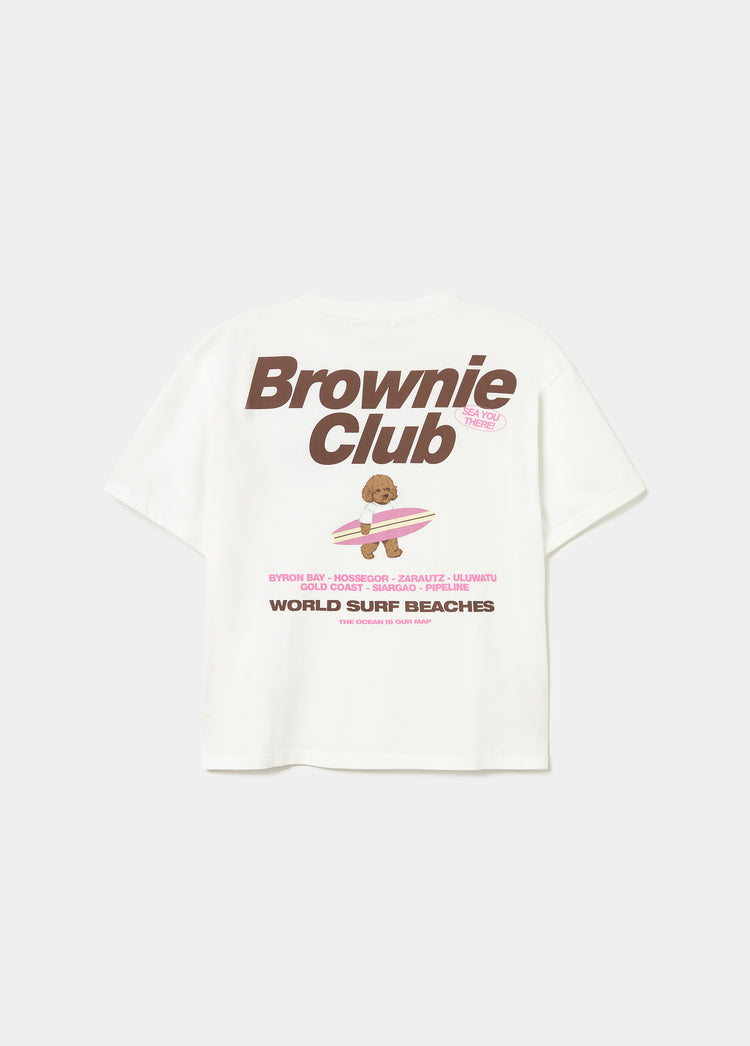 Camiseta blanca con estampado de un perro surfero y el texto Brownie Club en la parte trasera