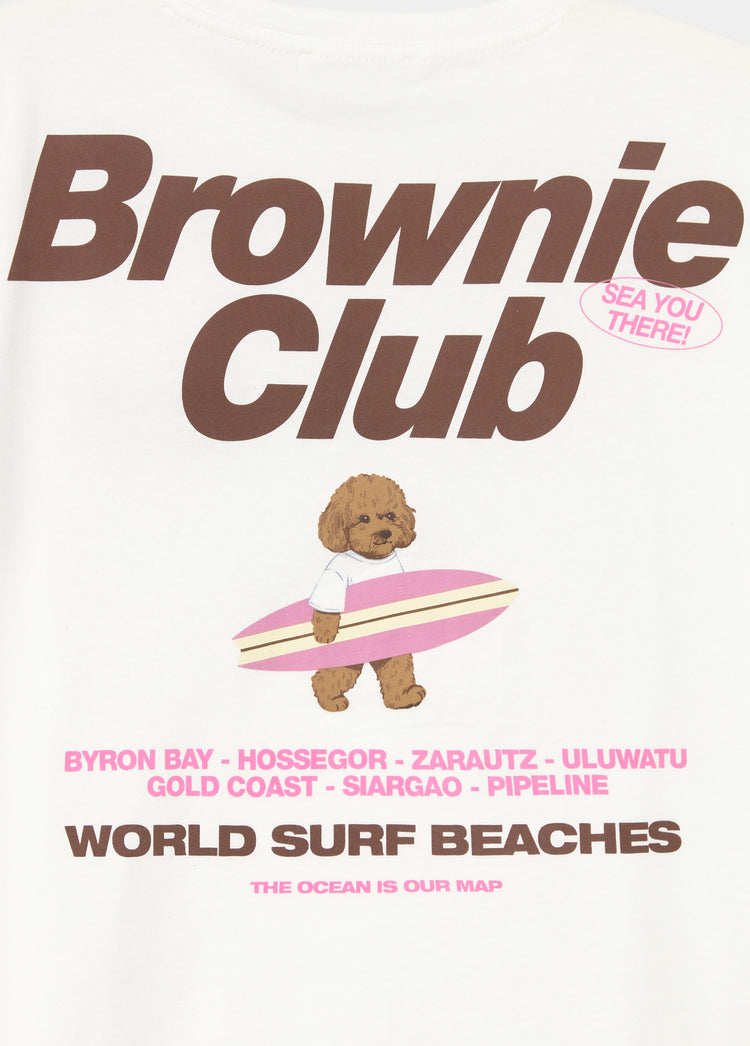 Camiseta blanca de corte clásico con estampado de un perrito surfero y el texto Brownie Club en tonos marrones y rosas
