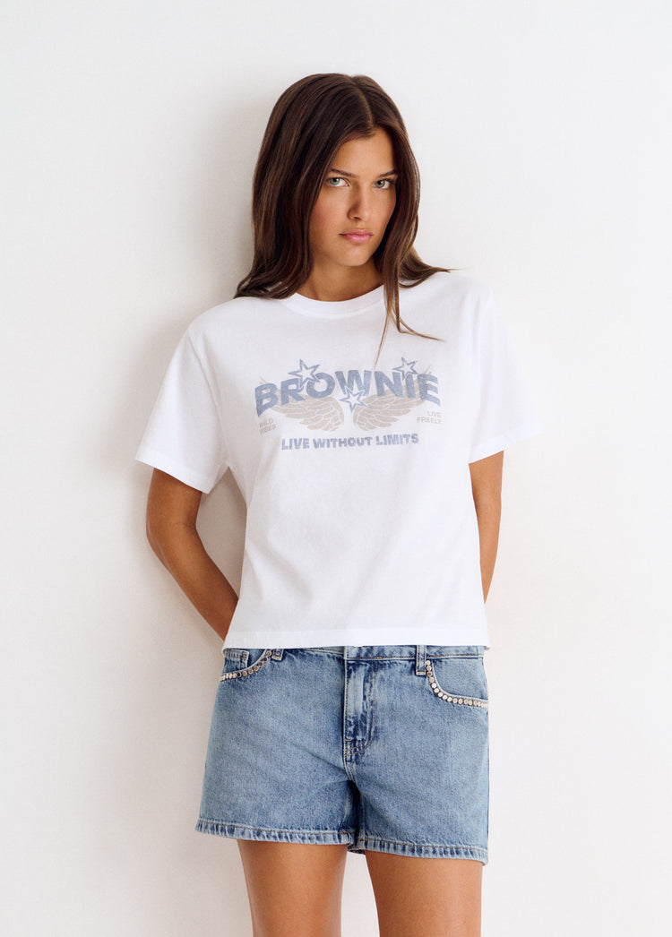 Camiseta blanca de manga corta con estampado de alas y letras glitter