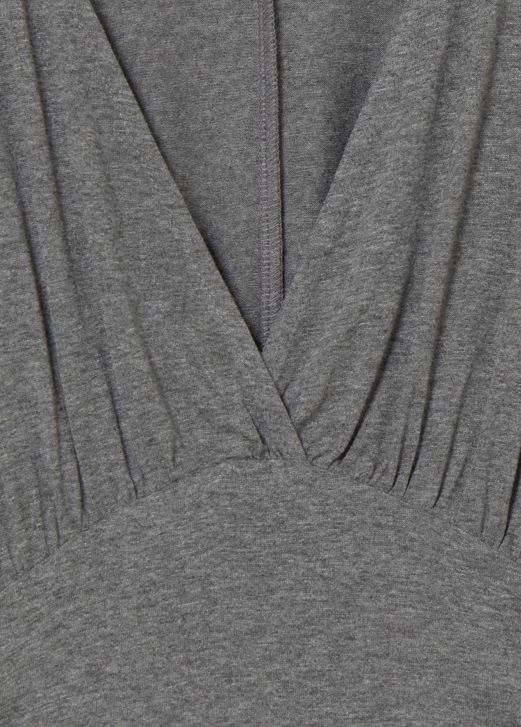 Camiseta entallada de gris vigore con escote en V y cintura ceñida vista en primer plano.