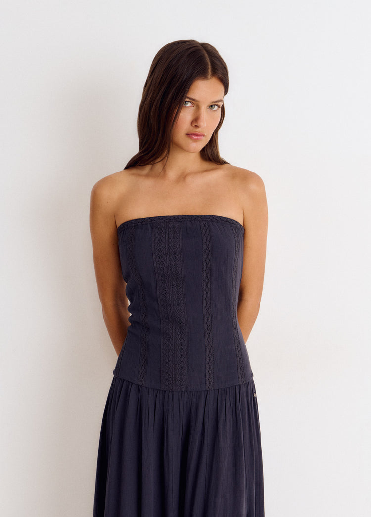 Vestido largo bandeau de encaje antracita con falda plisada y corte ajustado en el torso