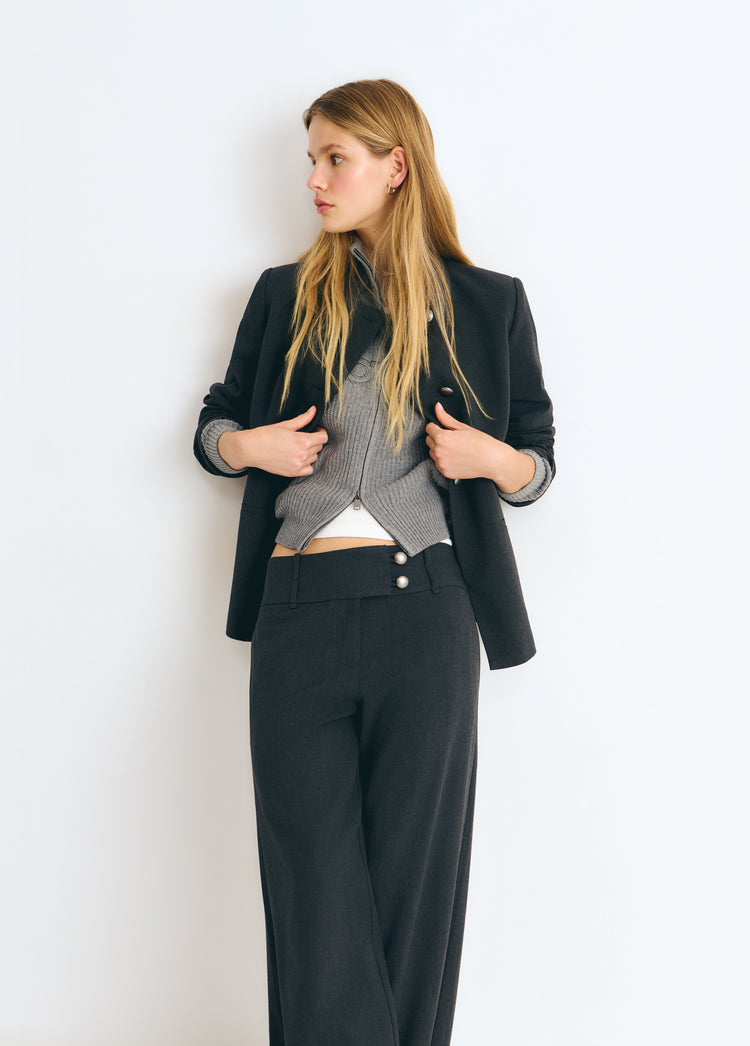 Pantalón gris oscuro de talle bajo y pierna ancha lucido con chaqueta y jersey
