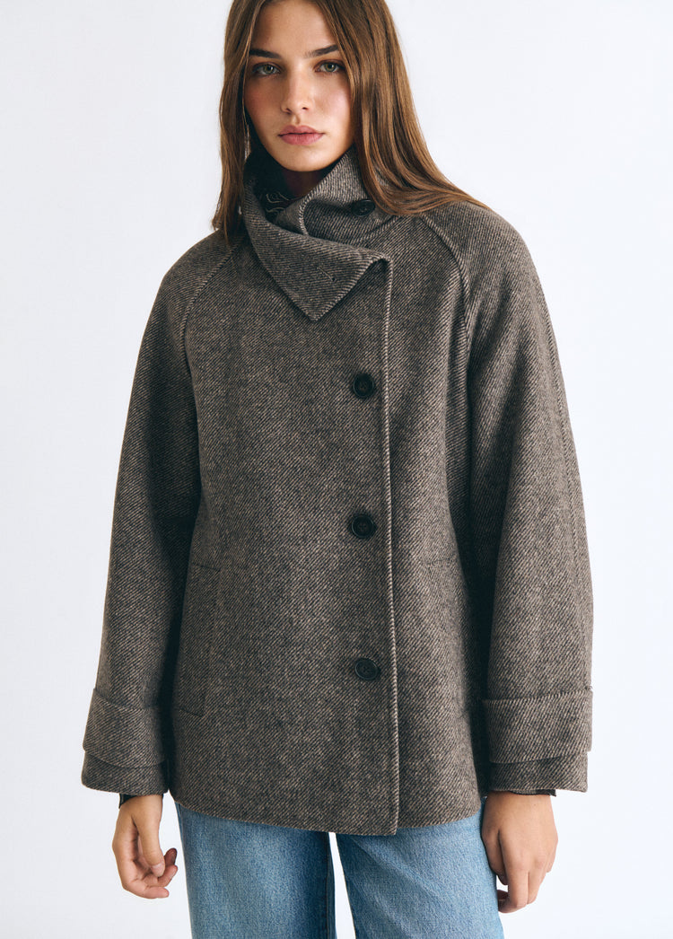 Abrigo de lana color topo con cuello subido y botones negros sobre modelo