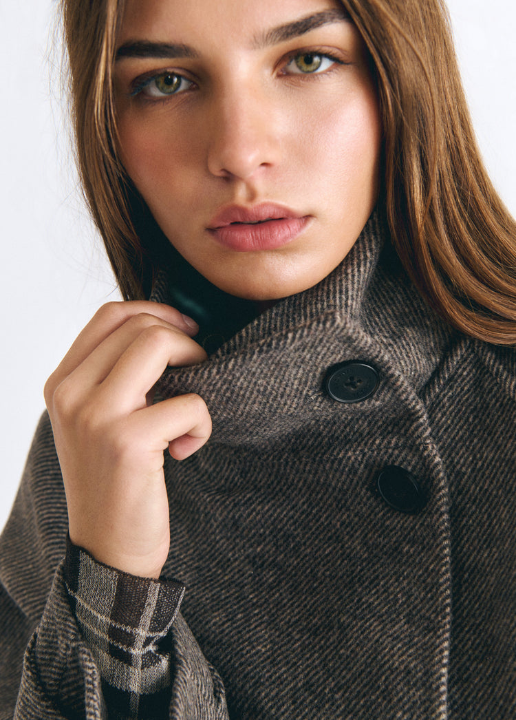 Abrigo de lana color topo con cuello subido y botones negros sobre modelo