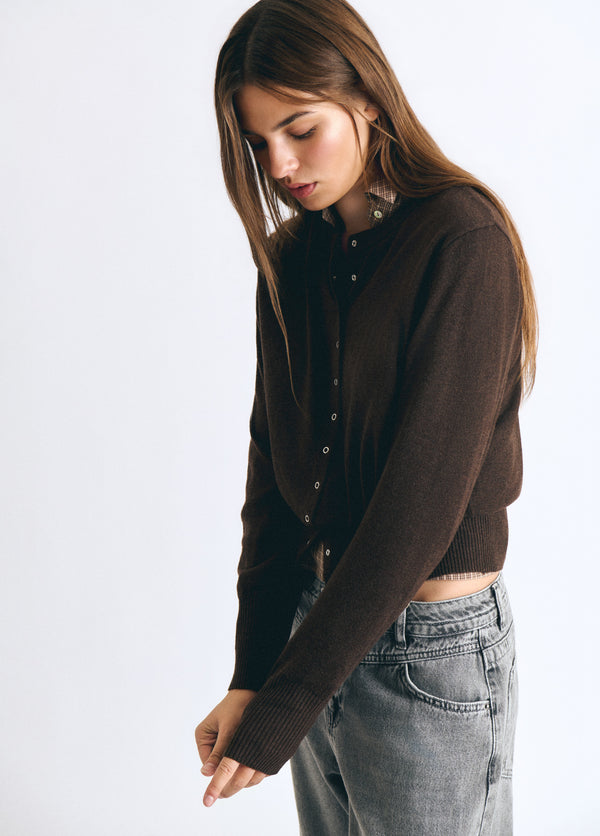 Chaqueta de punto marrón con botones sobre modelo combinada con vaqueros claros
