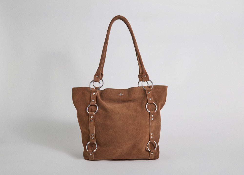 Bolso shopper de piel camel luciendo sus aros metálicos en vista lateral