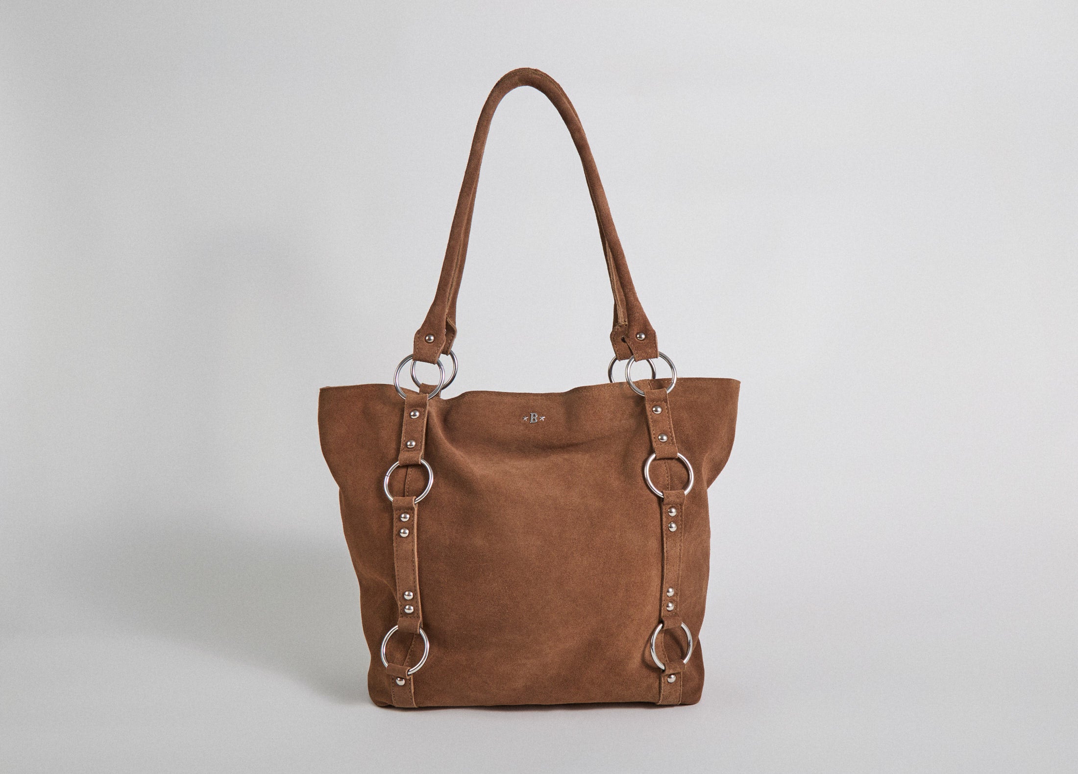 Bolso shopper de piel camel luciendo sus aros metálicos en vista lateral