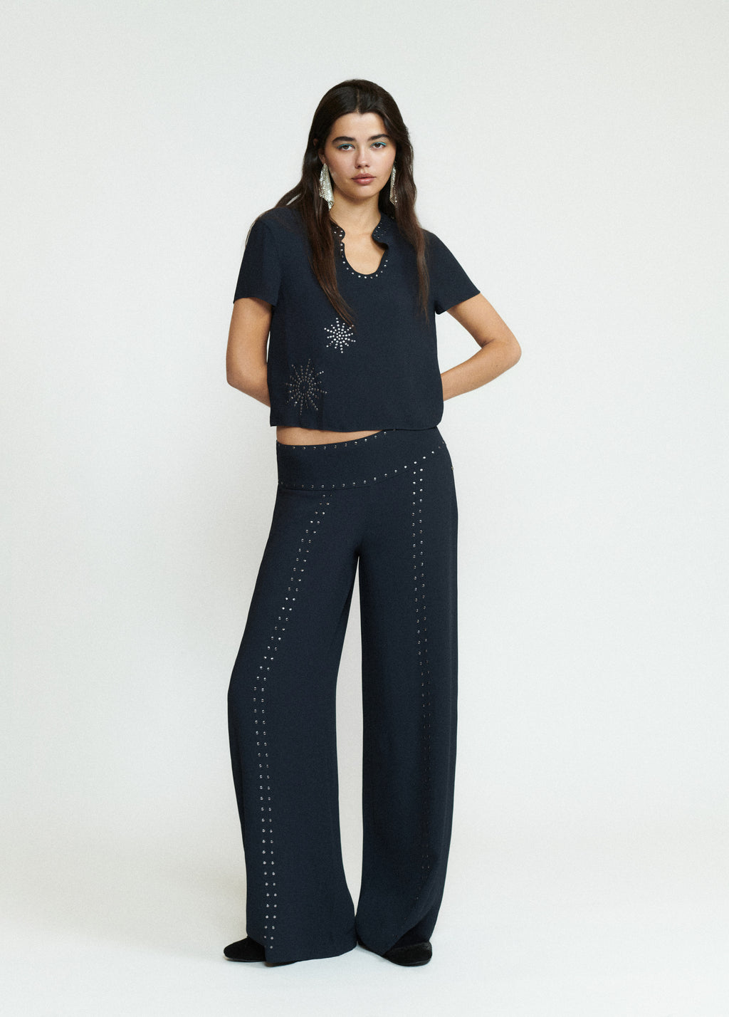 Blusa de manga corta en negro con estampado de tachas plateadas sobre el pecho
