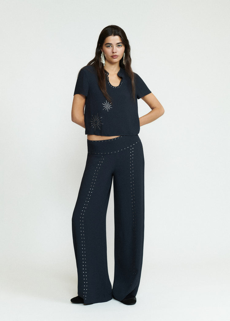 Blusa de manga corta en negro con estampado de tachas plateadas sobre el pecho