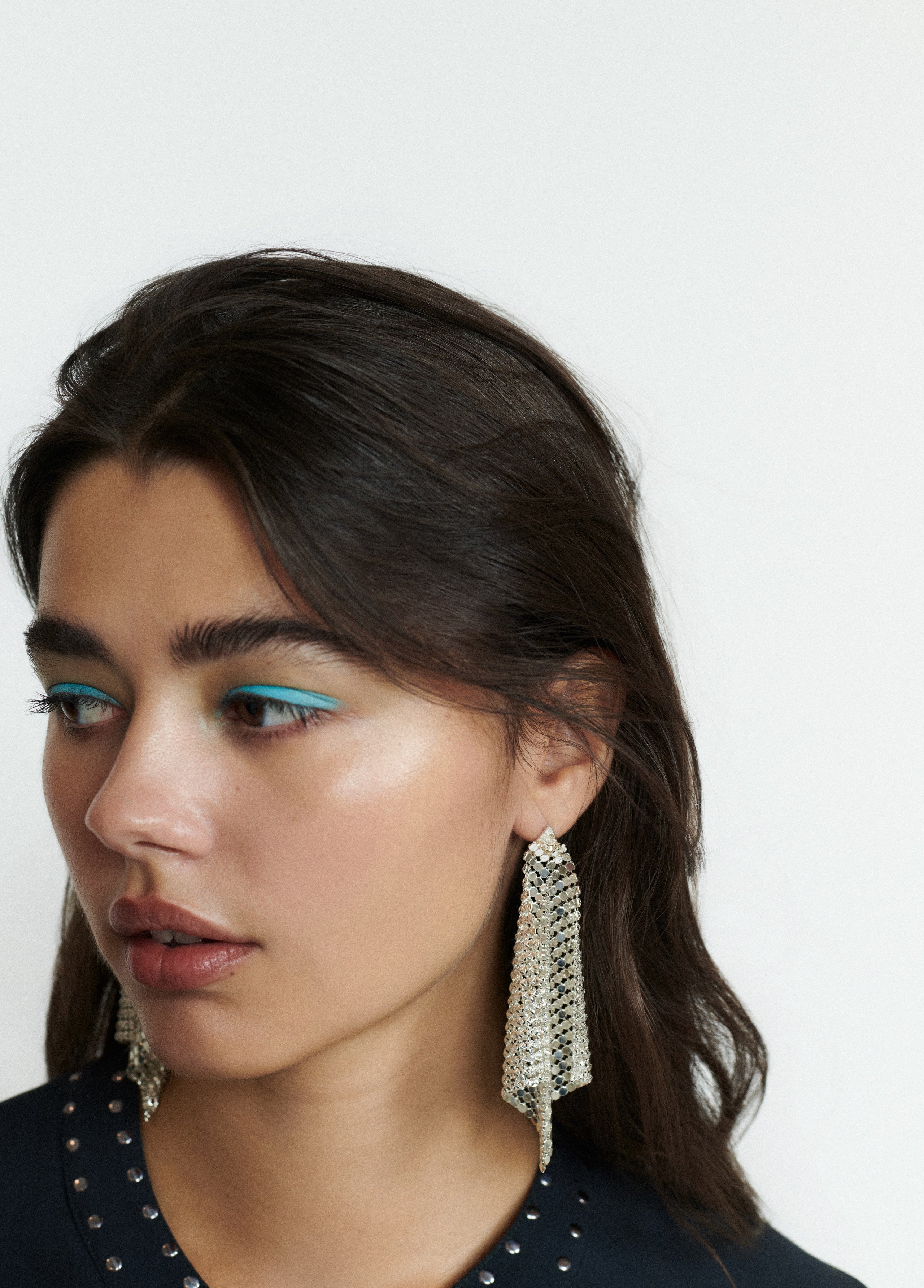 Pendientes de malla metálica en forma de rombo de color plata lucidos sobre modelo