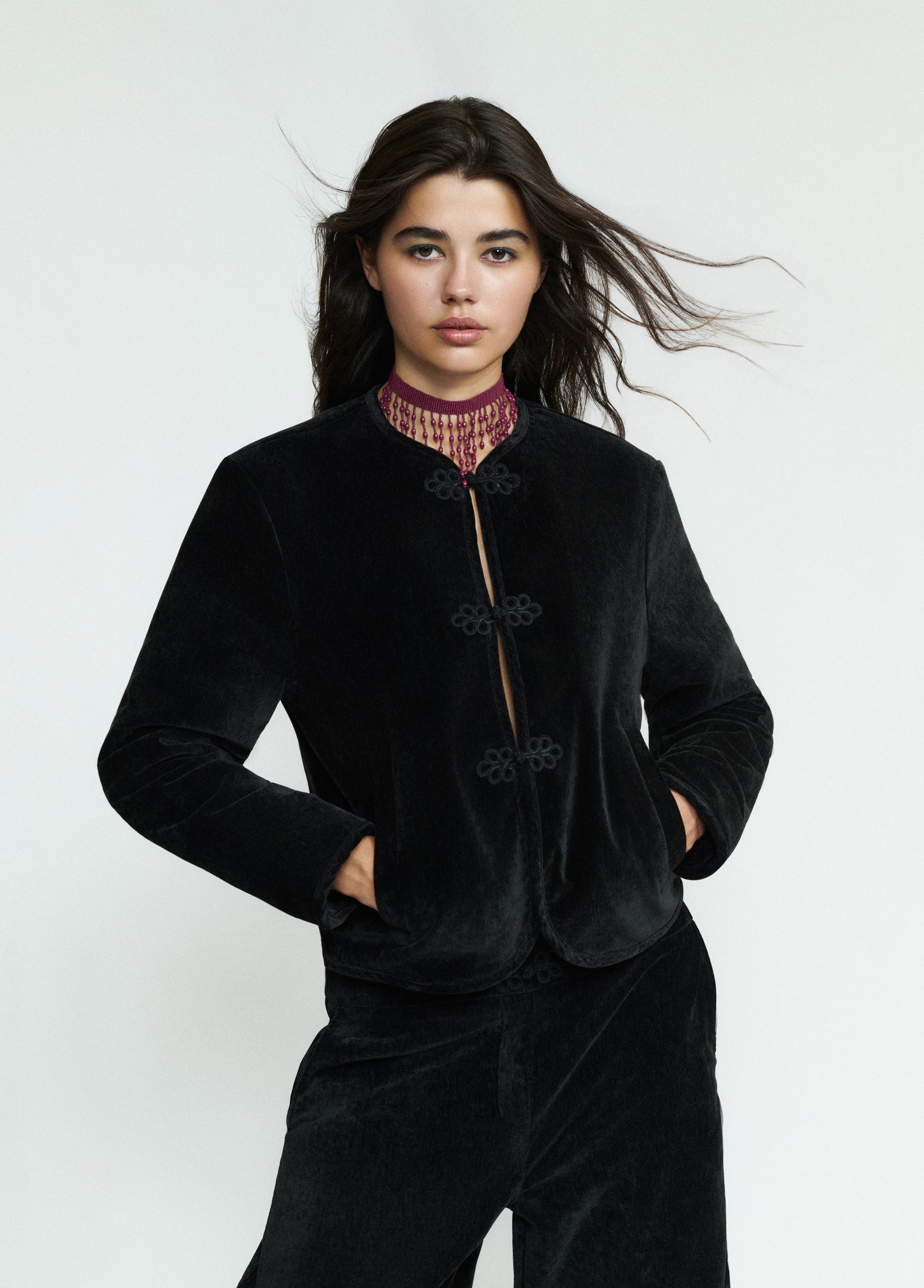 Chaqueta de terciopelo negro con alamares vista frontal sobre modelo