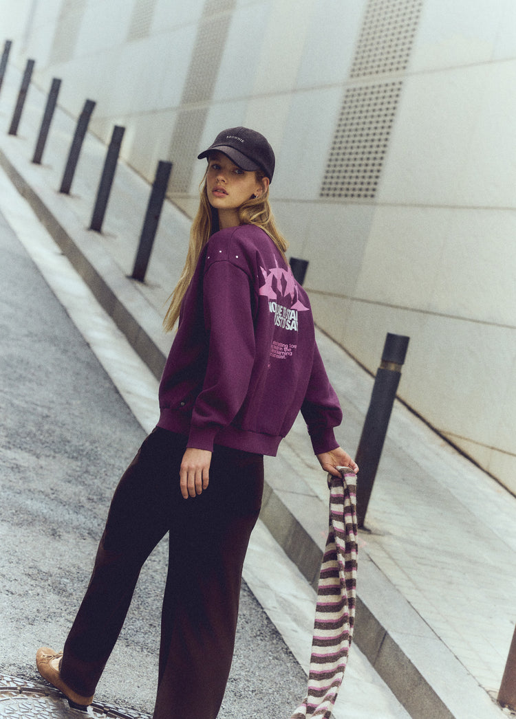 Sudadera de color granate con estampado de estrellas y tachas vista lateral sobre modelo