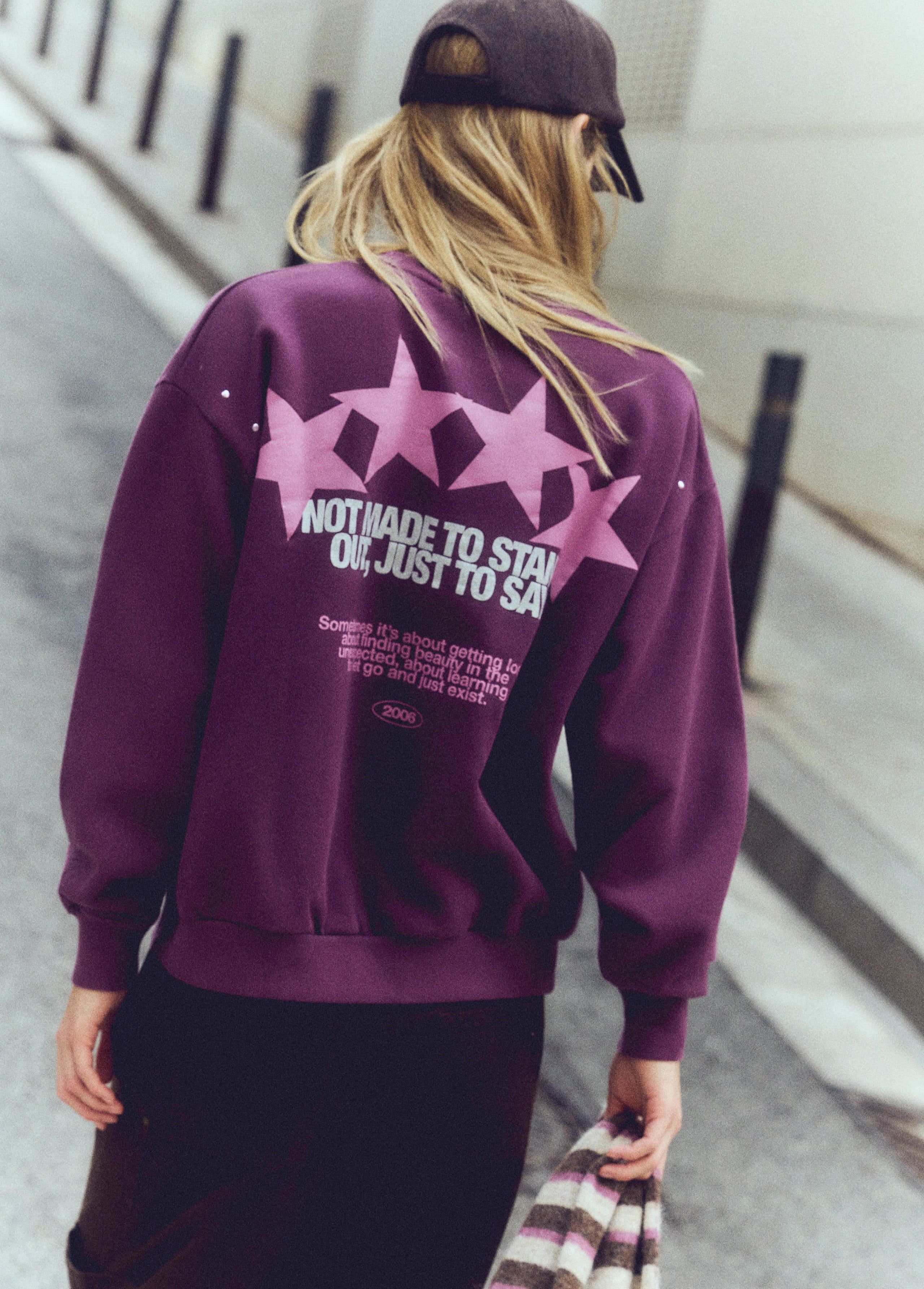 Sudadera de color granate con estampado de estrellas y texto en la espalda