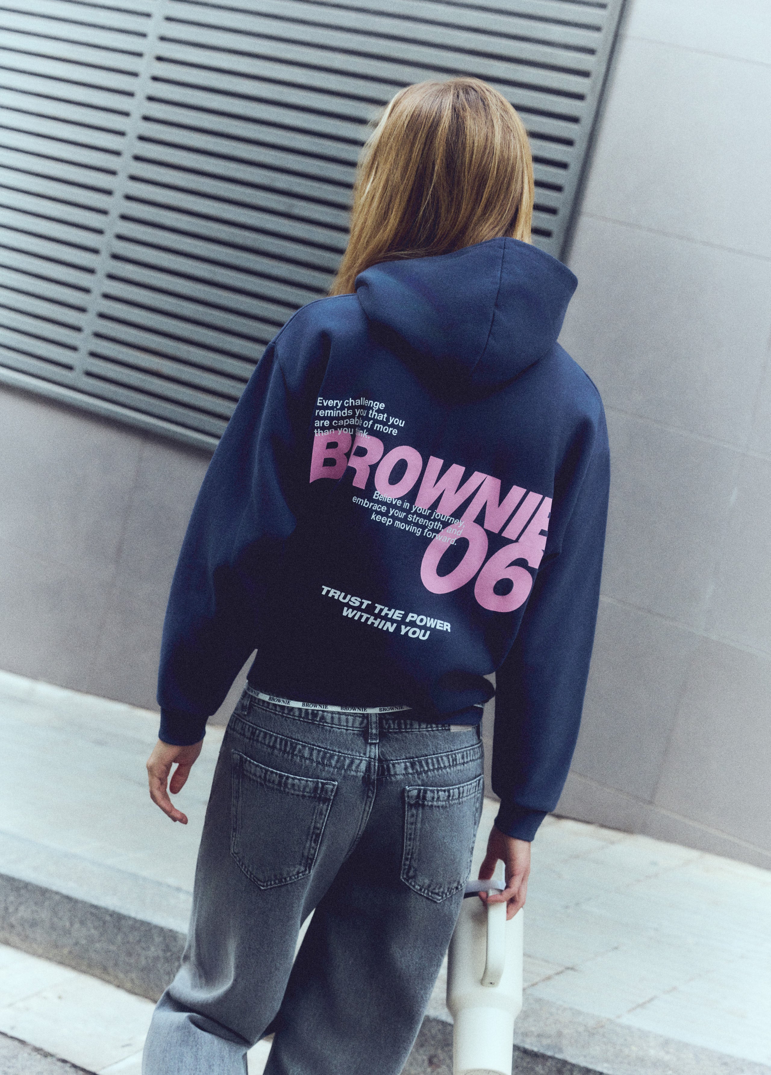 Sudadera de capucha marino luciendo el logotipo bordado en blanco sobre el pecho