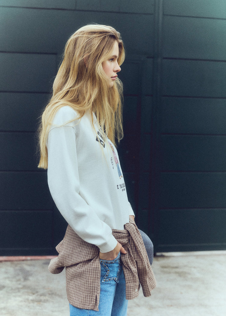 Sudadera de color crudo con estampado de un perro y la palabra brownie vista de perfil