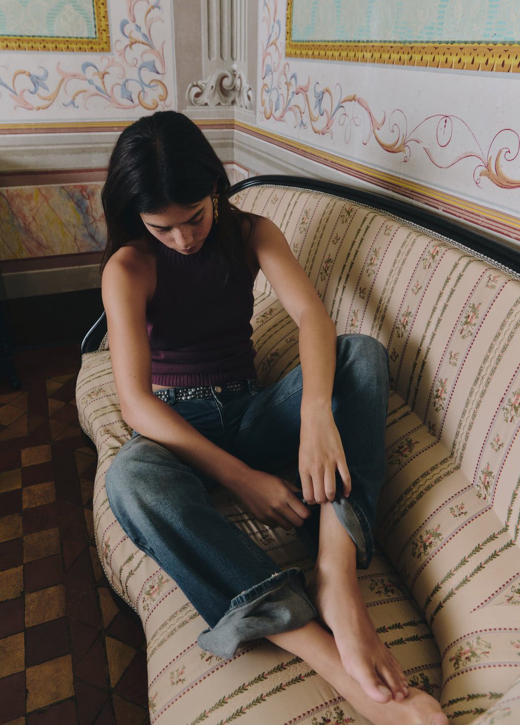 Vaqueros de color azul medio con cinturilla de tejano tachado, vistos desde arriba con los bajos remangados
