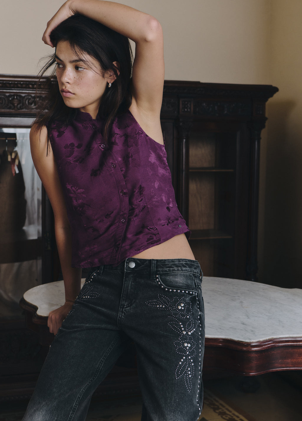 Top lila de tejido jacquard con botones, visto de frente sobre vaqueros oscuros