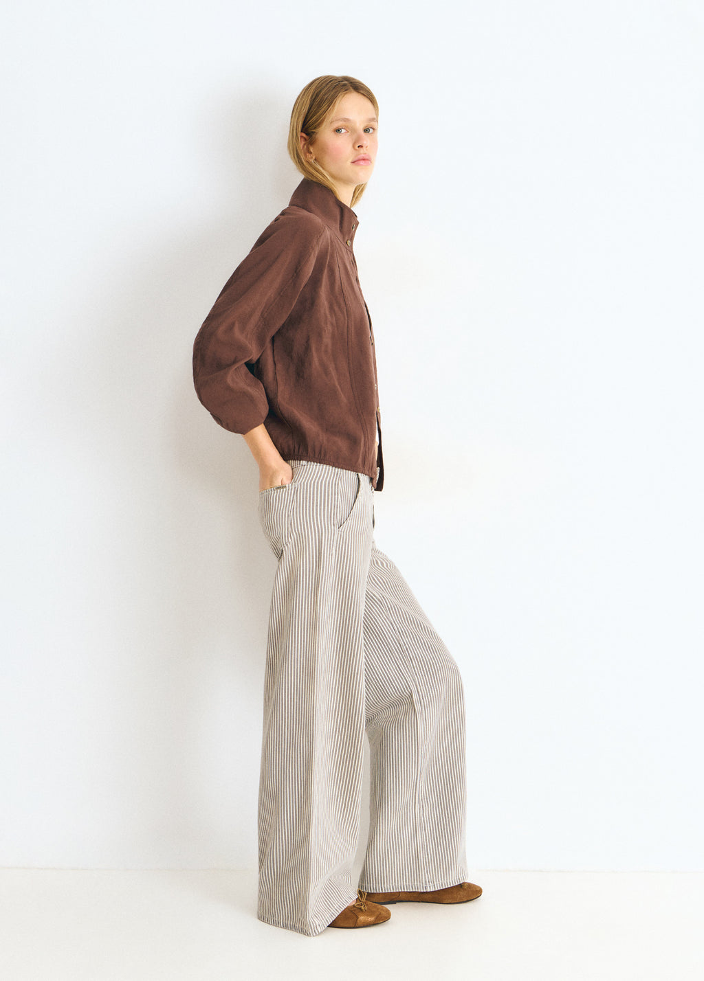 Pantalón de rayas finas gris con corte amplio visto de perfil