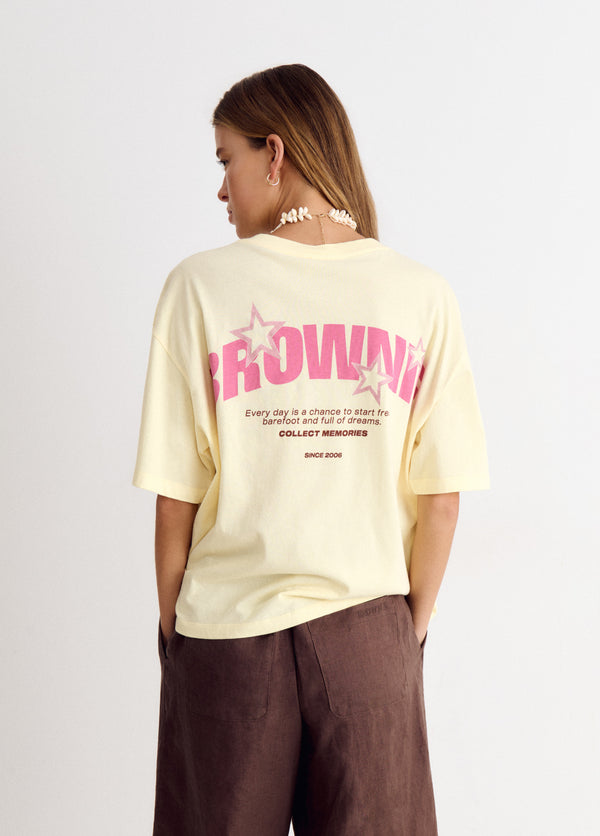 Camiseta amarilla de corte holgado con estampado de estrellas y letras en la espalda