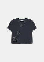 Blusa de manga corta en negro con cuello y escote decorados con tachas plateadas sobre modelo