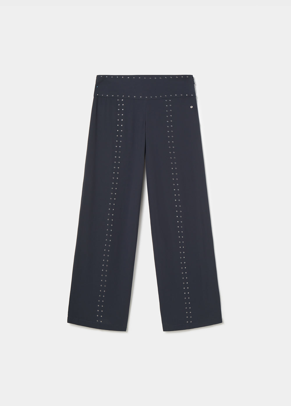 Pantalón largo negro de corte amplio con detalles de tachas sobre modelo