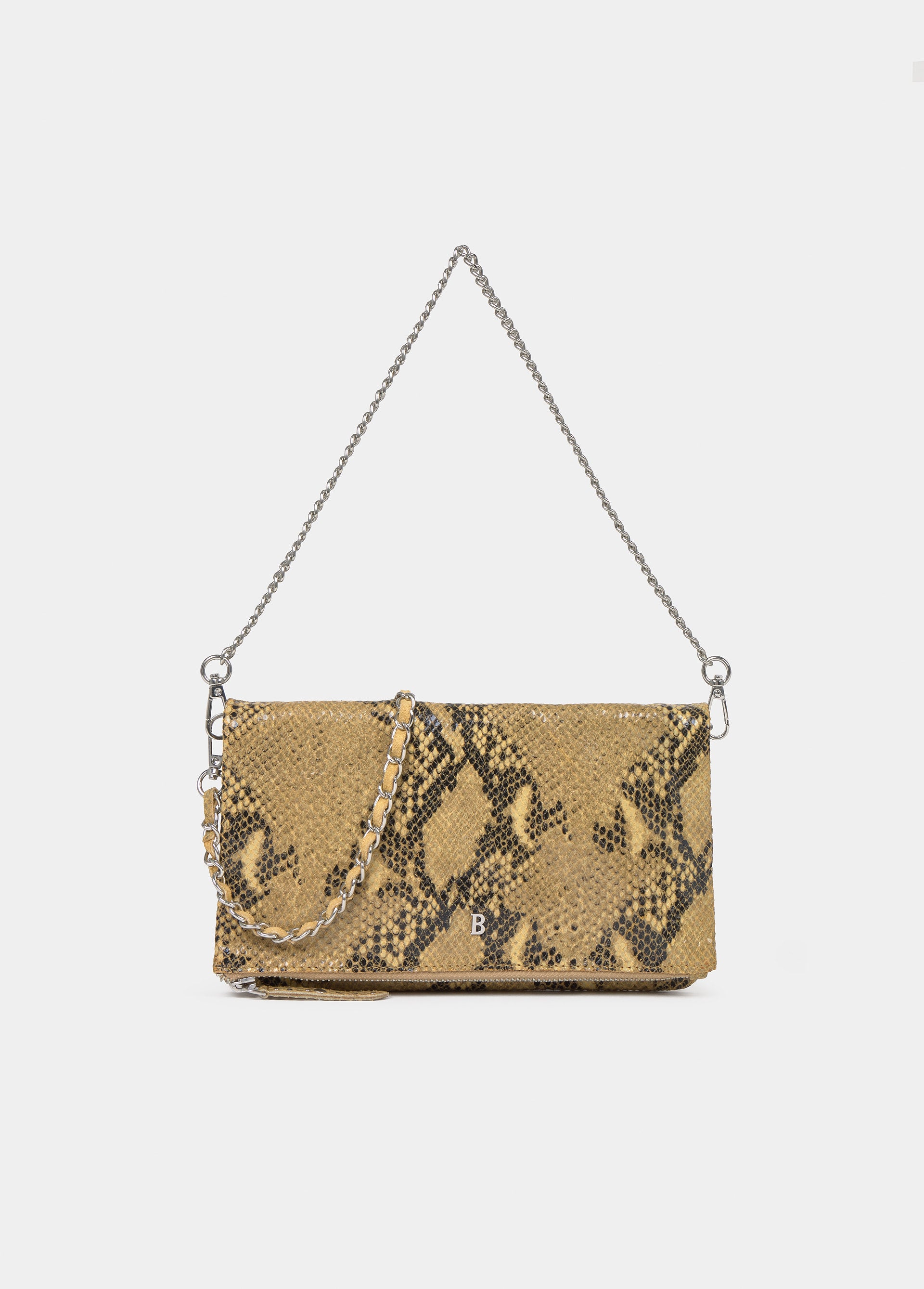 Bolso de solapa con estampado de serpiente en mostaza colgado al hombro sobre modelo