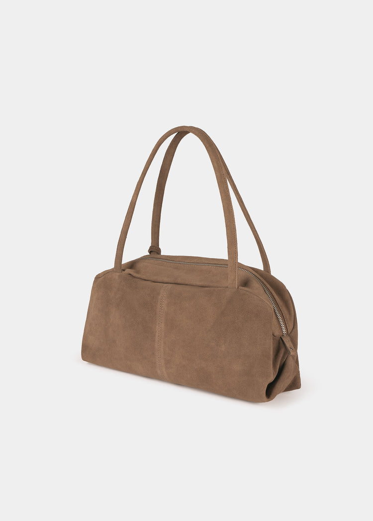 Bolso baguette de ante en tono taupe visto de perfil con cremallera lateral y asas erguidas