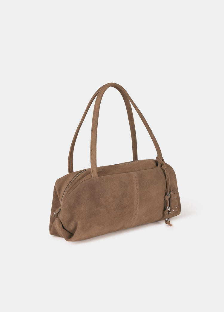 Bolso baguette de ante taupe visto de frente con asas erguidas y charms colgantes